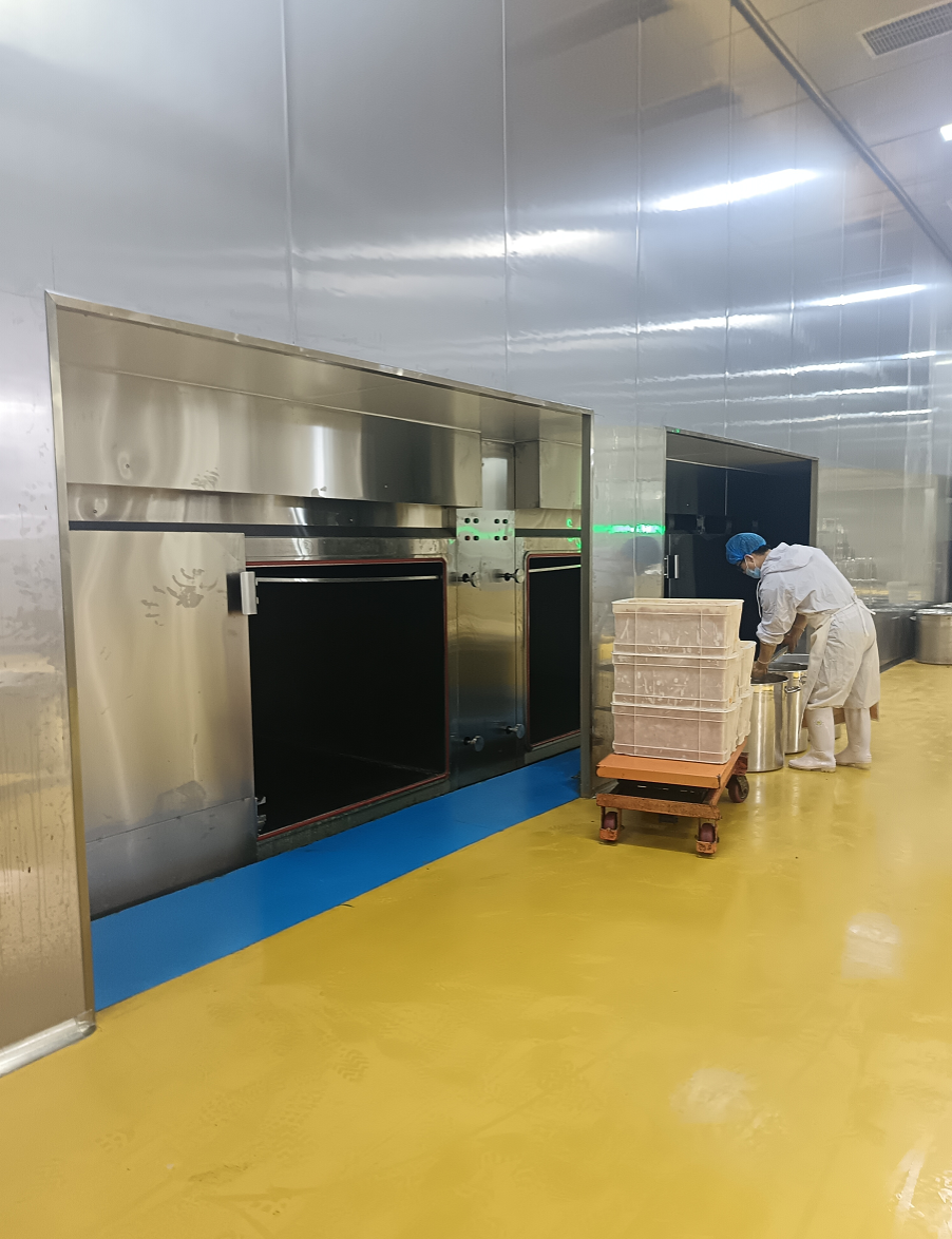 预处理车间进料端:工人正将高温食材推入宽敞的预冷舱内。大昌重型预冷设备容量大、承重强,非普通家用级别,专为高强度、大批量的工业连续生产而生。 预处理车间进料端:工人正将高温食材推入宽敞的预冷舱内。大昌重型预冷设备容量大、承重强,非普通家用级别,专为高强度、大批量的工业连续生产而生。